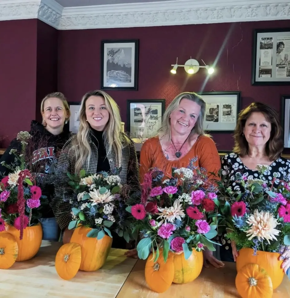 Workshop guests with the pumpkin floral centrepieces they made