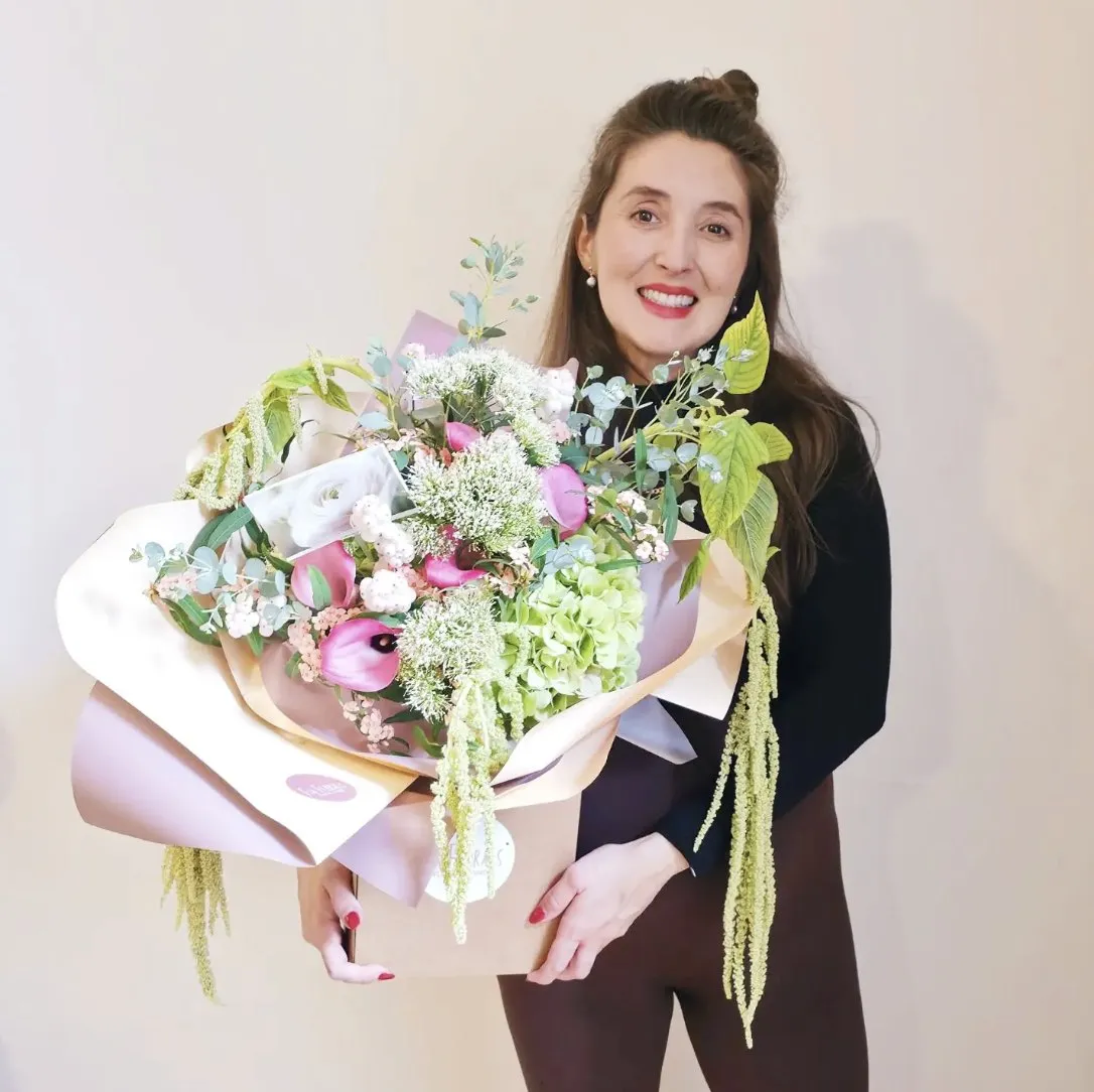 Sophia holding a large hand-tied bouquet of pink calla lilies, hydrangea and amaranthus